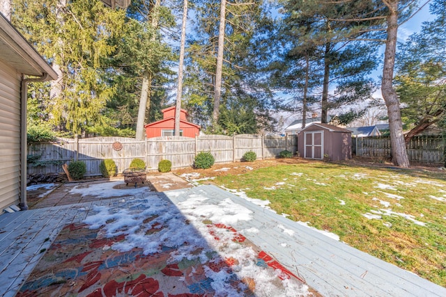 view of yard featuring a fire pit, a patio area, a deck, and a storage shed