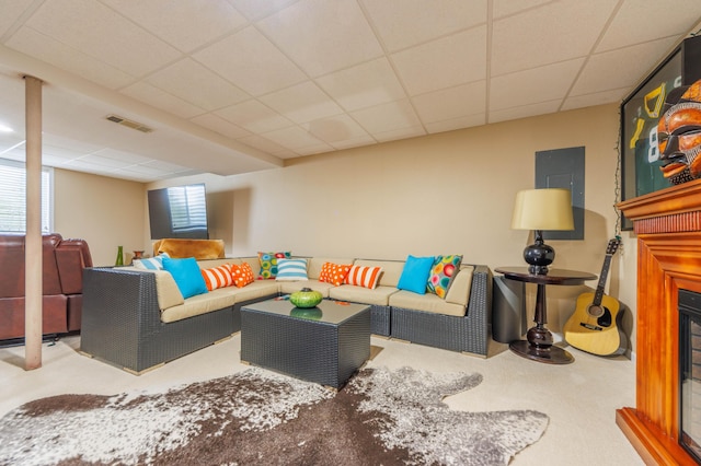 carpeted living room featuring a drop ceiling