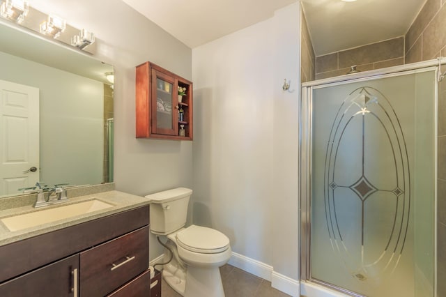 bathroom with vanity, tile patterned flooring, a shower with shower door, and toilet