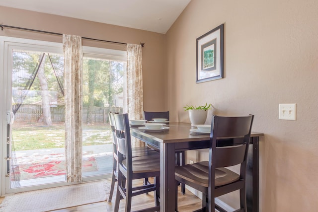 dining space featuring vaulted ceiling