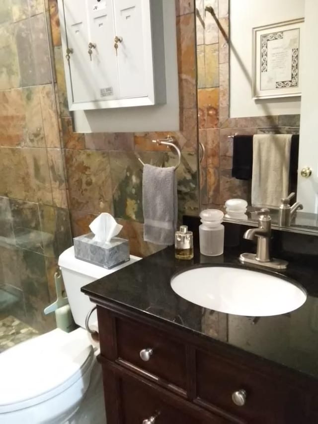 bathroom with vanity, tile walls, backsplash, and toilet