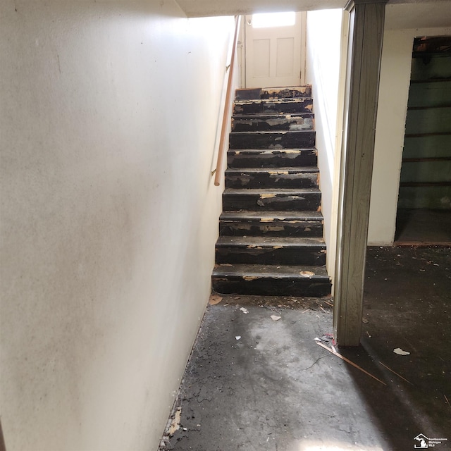 staircase featuring concrete flooring