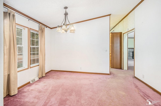 carpeted spare room with an inviting chandelier, ornamental molding, and a textured ceiling