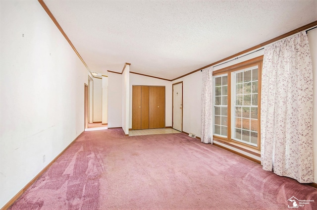 carpeted spare room with ornamental molding and a textured ceiling