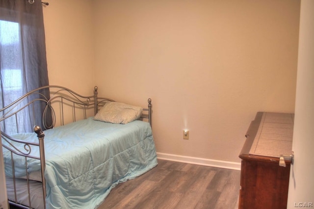 bedroom with dark wood-type flooring