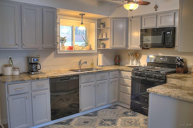 kitchen featuring sink, ceiling fan, light stone counters, black appliances, and decorative light fixtures