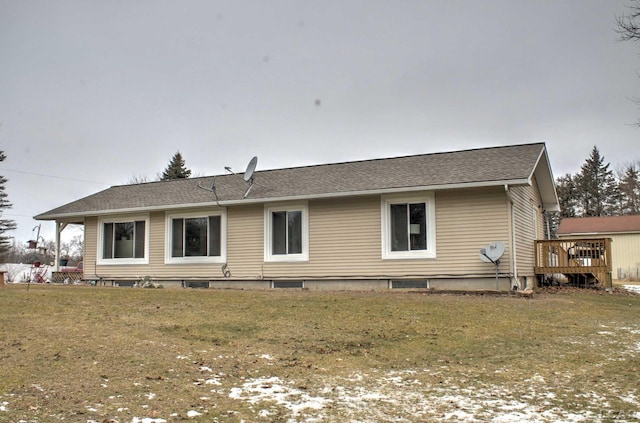 rear view of house featuring a deck and a lawn