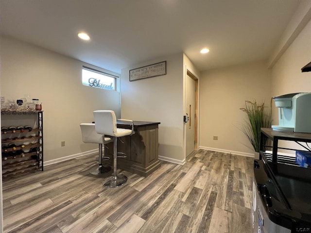 office area featuring dark wood-type flooring and bar area