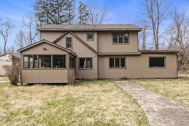 rear view of house with a sunroom and a yard