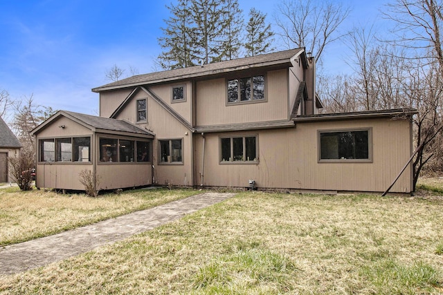 back of house with a yard and a sunroom