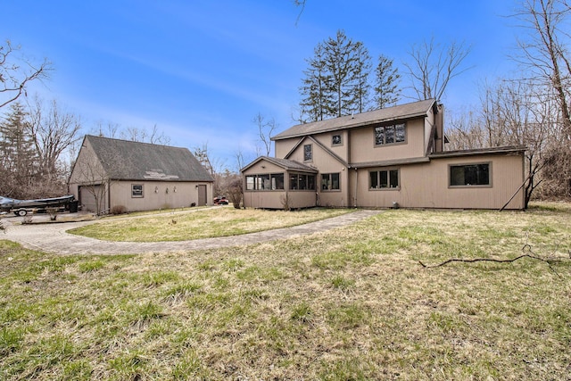 rear view of property with a lawn and a sunroom