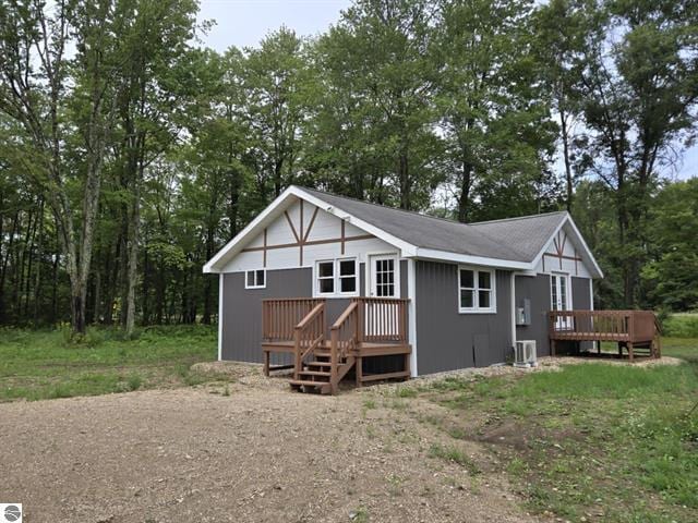 rear view of property featuring a wooden deck and central AC unit