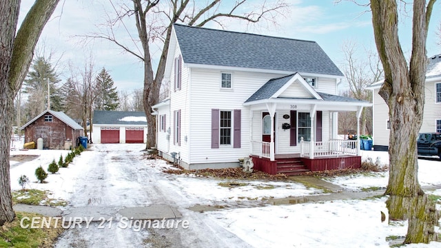 view of front of home with a garage and an outbuilding