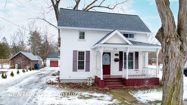 view of front of property with a garage, an outdoor structure, and covered porch