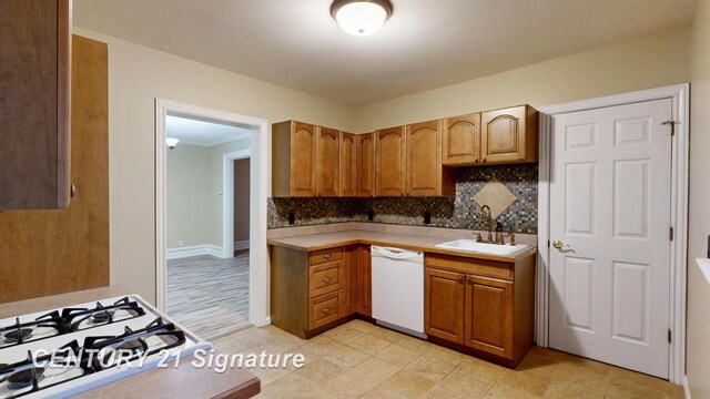 kitchen with cooktop, dishwasher, sink, and backsplash