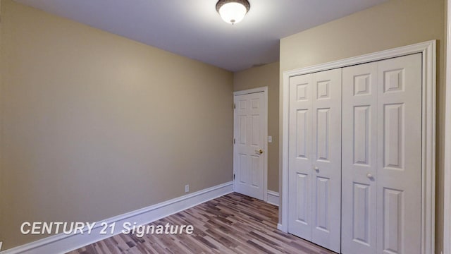 unfurnished bedroom with wood-type flooring and a closet