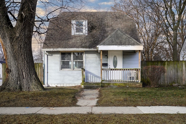 view of front of property with covered porch and a lawn