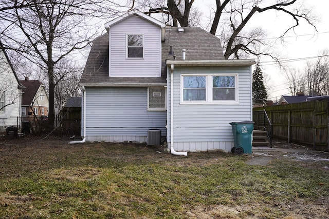 back of property featuring cooling unit and a lawn