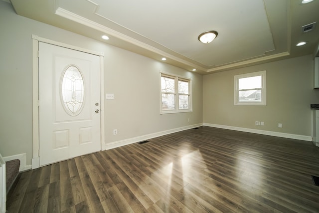 entrance foyer with crown molding, dark hardwood / wood-style flooring, and a raised ceiling