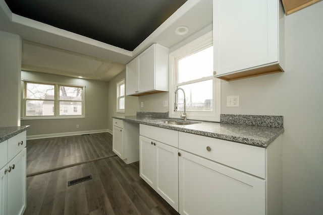 kitchen featuring a tray ceiling, dark hardwood / wood-style flooring, sink, and white cabinets