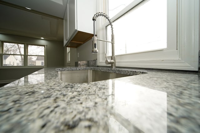 details with light stone countertops and sink