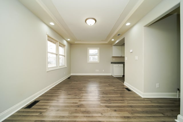 empty room featuring dark hardwood / wood-style floors and a raised ceiling