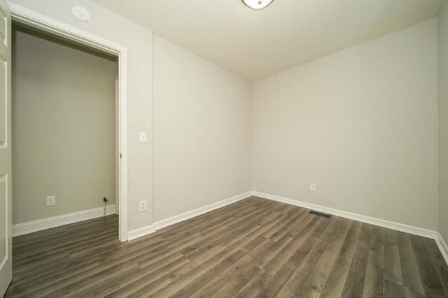 unfurnished room with dark wood-type flooring