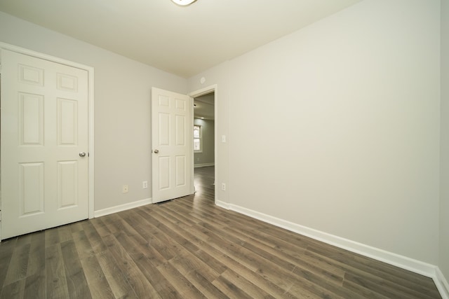 unfurnished bedroom with dark wood-type flooring