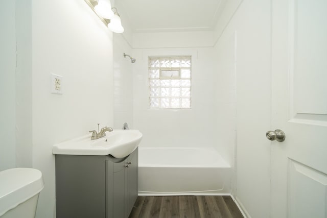 full bathroom with vanity, hardwood / wood-style floors, tiled shower / bath combo, and toilet