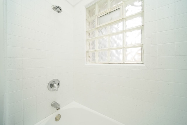 bathroom featuring tiled shower / bath