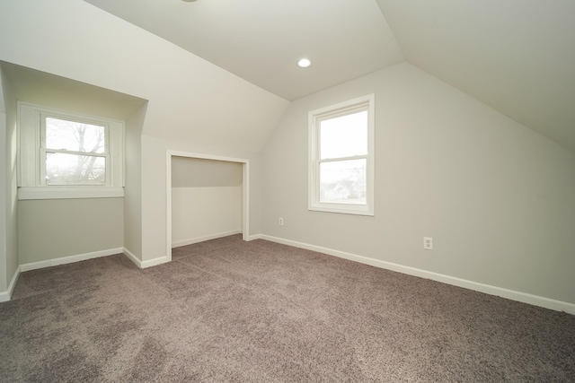 bonus room featuring lofted ceiling, a healthy amount of sunlight, and carpet flooring