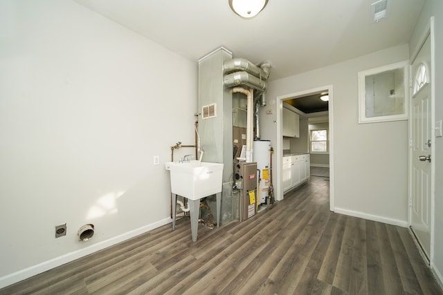 laundry room with gas water heater, electric panel, dark hardwood / wood-style floors, and hookup for an electric dryer