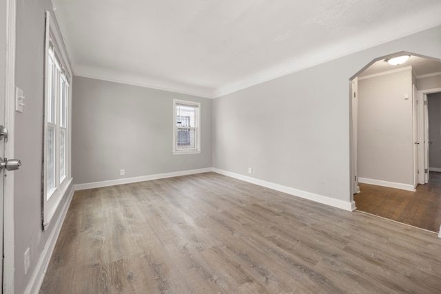 empty room featuring ornamental molding and hardwood / wood-style floors