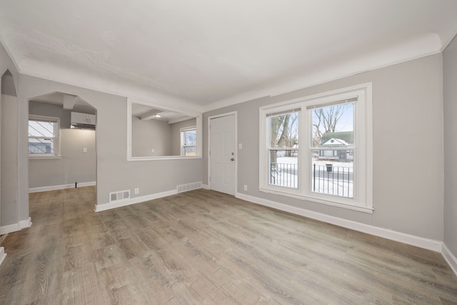 empty room with a wall mounted AC and light wood-type flooring