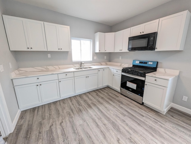 kitchen featuring white cabinetry, stainless steel range with gas stovetop, light hardwood / wood-style floors, and sink