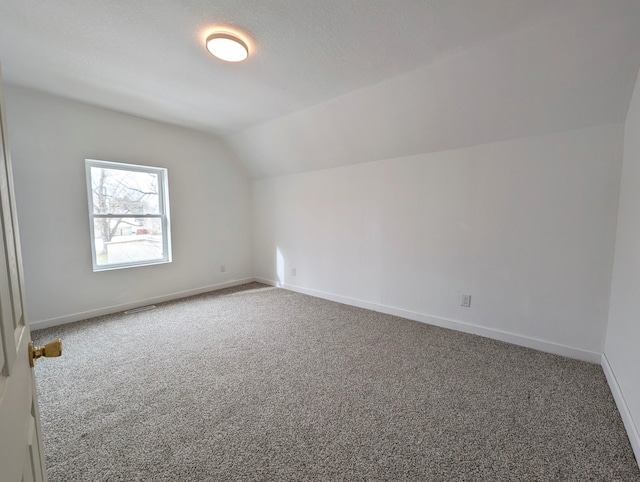 bonus room with lofted ceiling, carpet flooring, and a textured ceiling