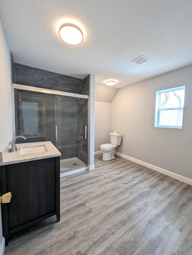 bathroom featuring toilet, an enclosed shower, a textured ceiling, vanity, and hardwood / wood-style floors