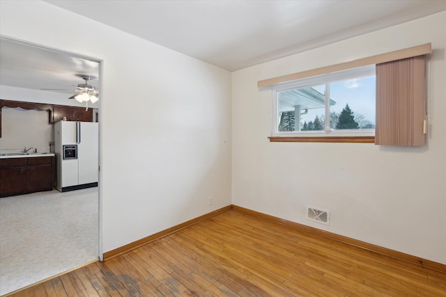 spare room featuring ceiling fan, sink, and light hardwood / wood-style floors