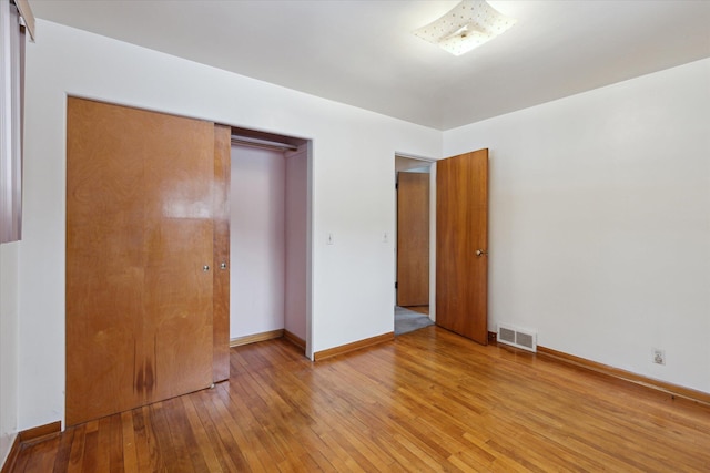 unfurnished bedroom featuring a closet and light wood-type flooring