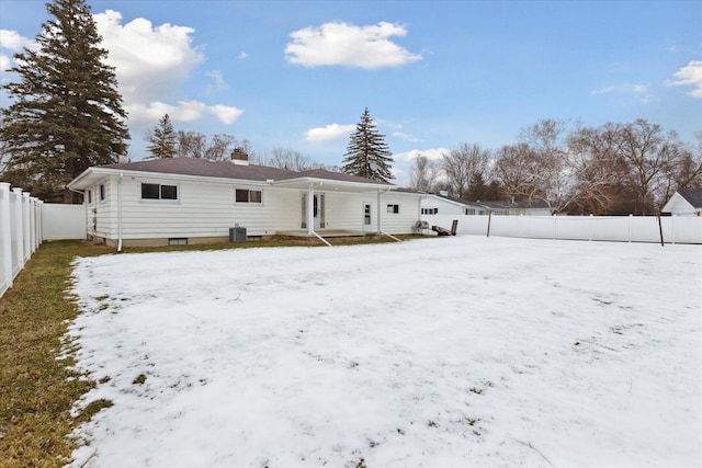 snow covered house featuring central AC unit