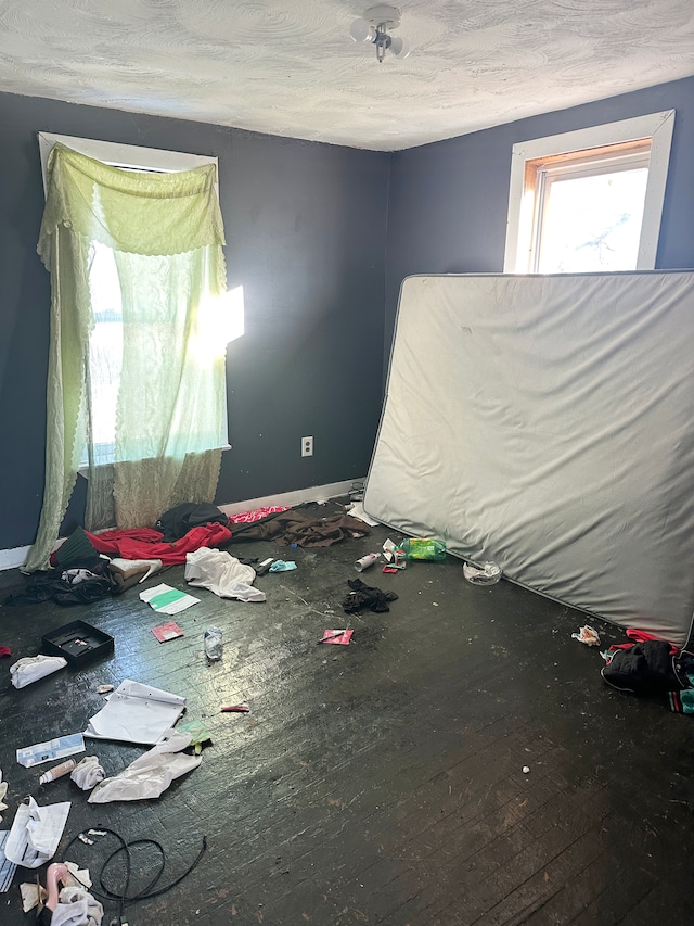 unfurnished bedroom with hardwood / wood-style flooring and a textured ceiling