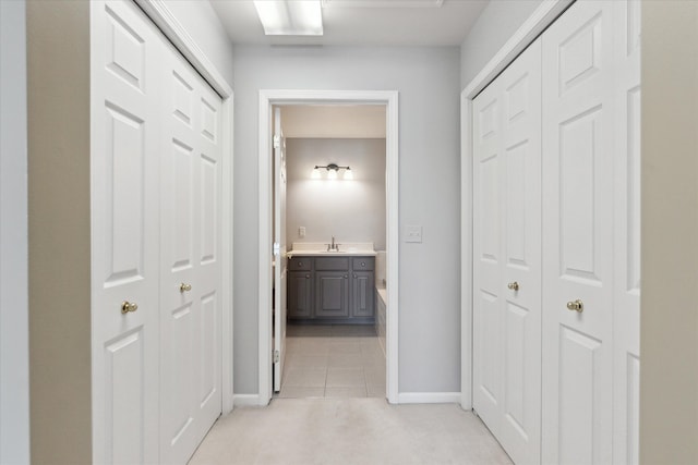 hall with light tile patterned flooring and sink