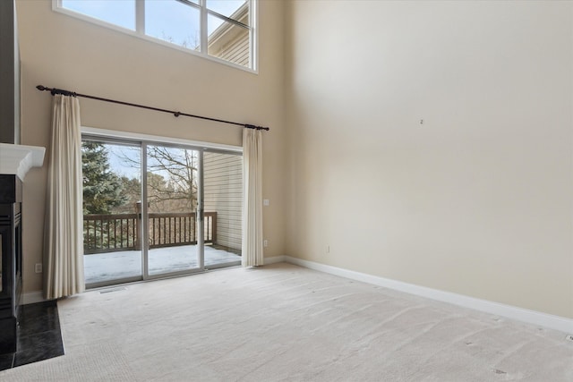 unfurnished living room featuring a high ceiling and carpet