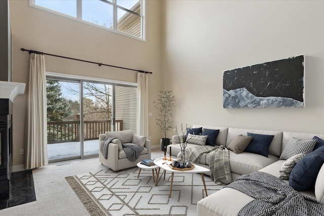 carpeted living room featuring a high ceiling