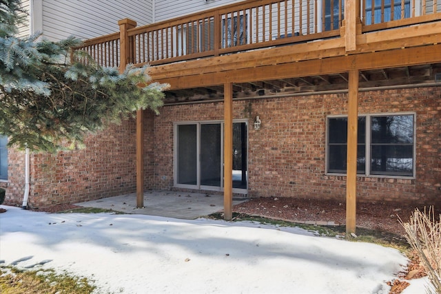 snow covered patio featuring a deck