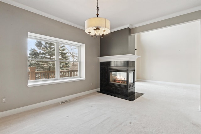 unfurnished living room with a fireplace, ornamental molding, a chandelier, and carpet