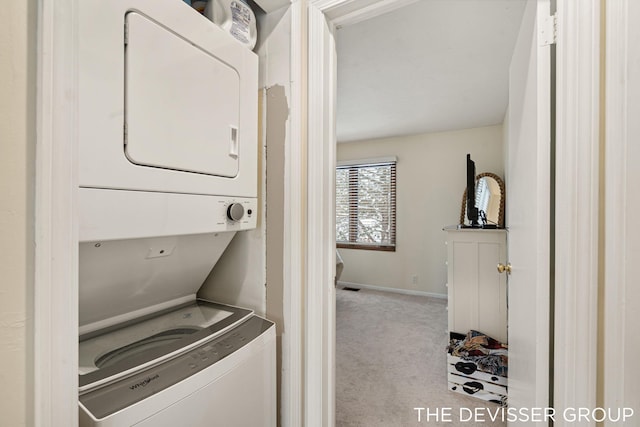 clothes washing area with stacked washer / drying machine and light carpet