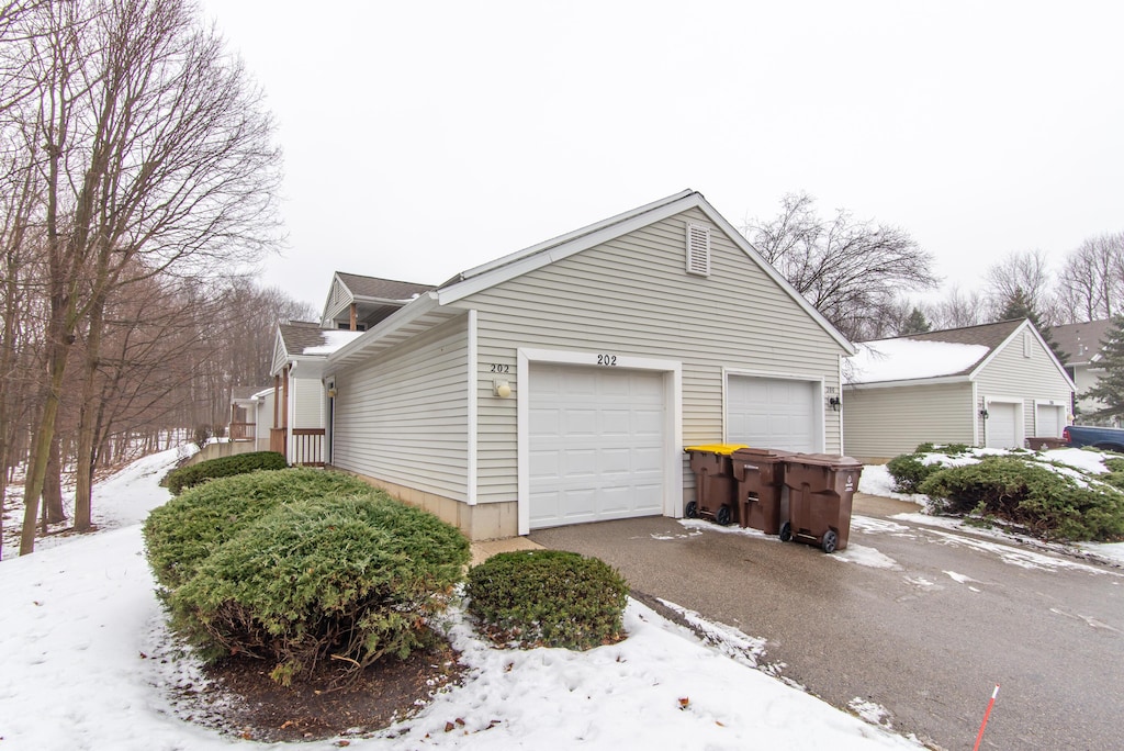 view of snow covered exterior with a garage