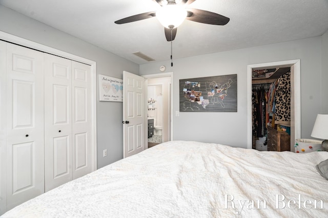 bedroom featuring a spacious closet, a closet, and ceiling fan