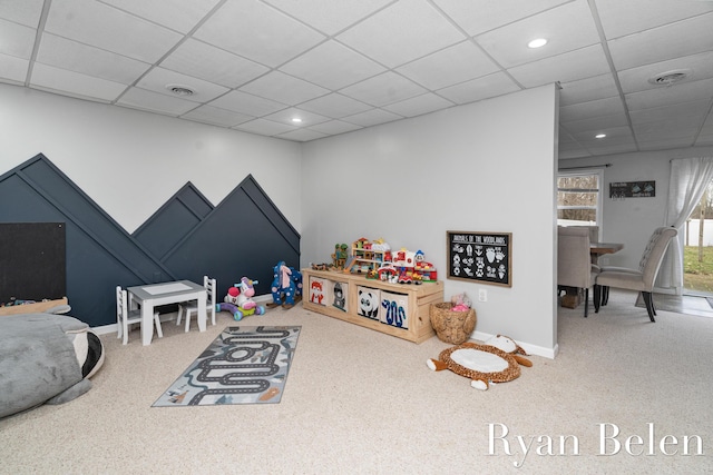 game room with a paneled ceiling and carpet